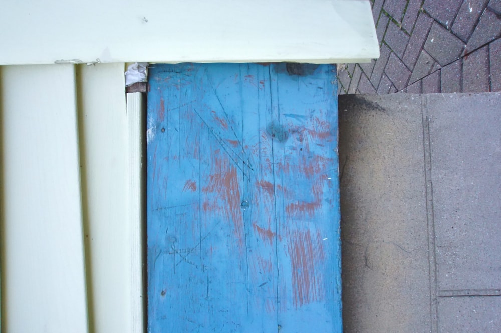 a close up of a blue door on a sidewalk
