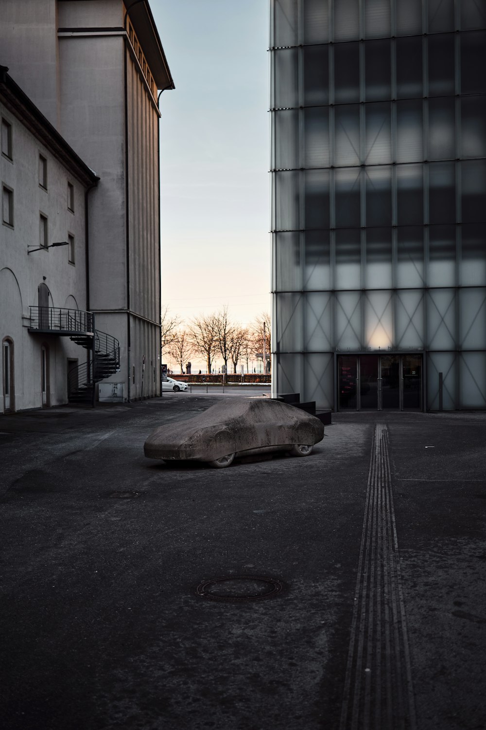 a car parked in a parking lot next to a tall building