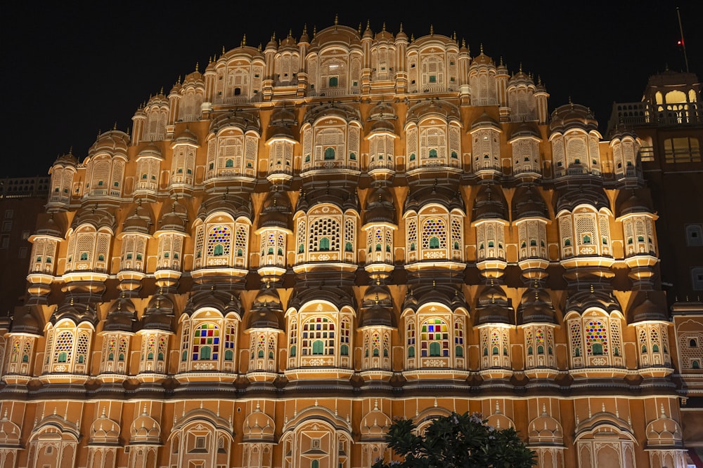 Un edificio alto con muchas ventanas iluminadas por la noche