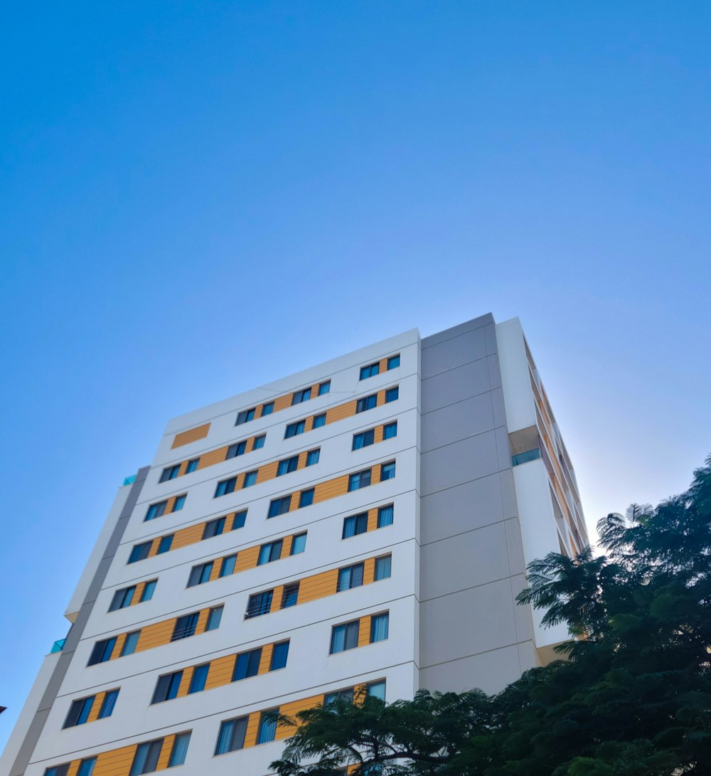 a tall white building with yellow and blue windows