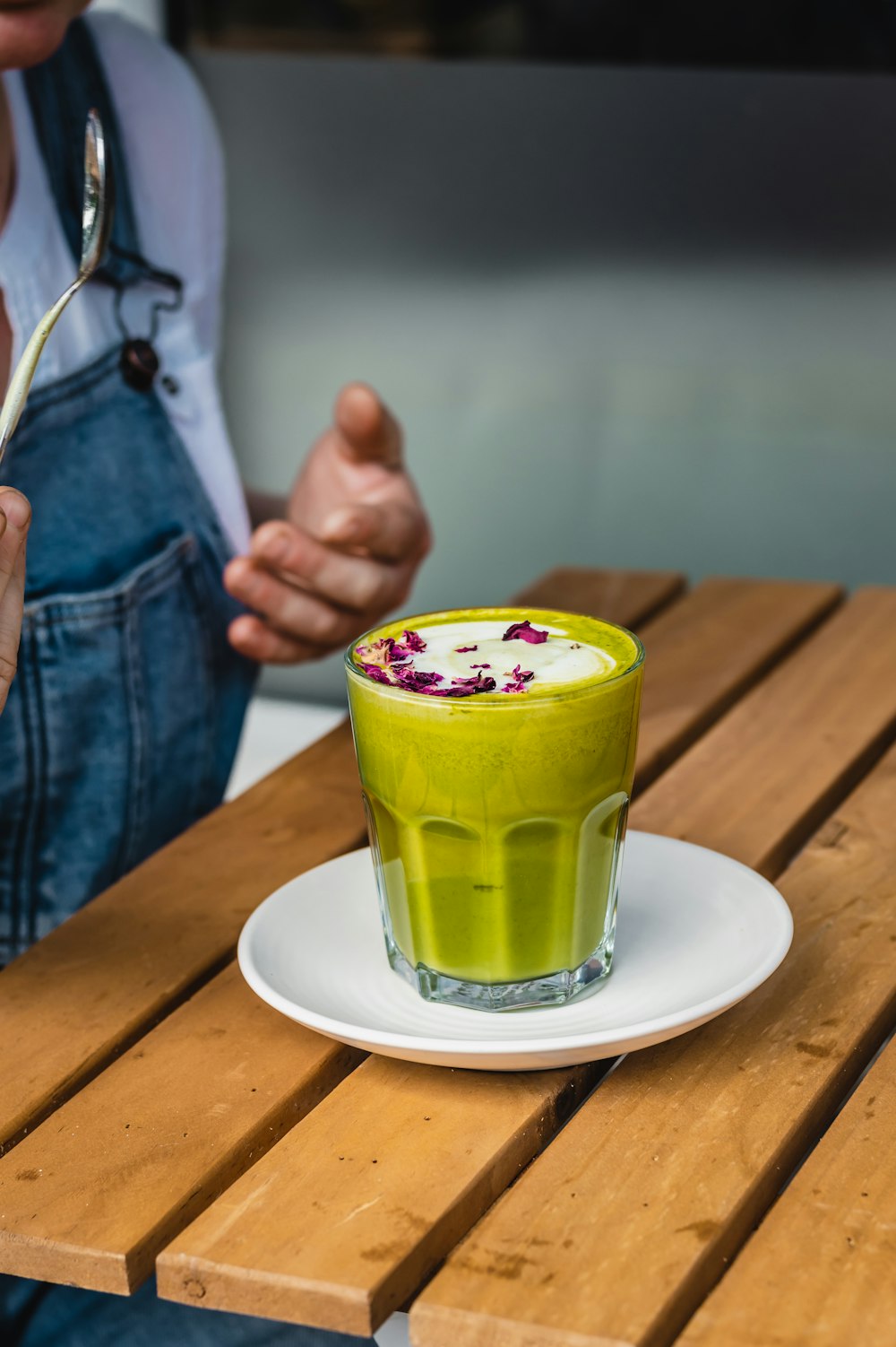 a person sitting at a table with a green drink