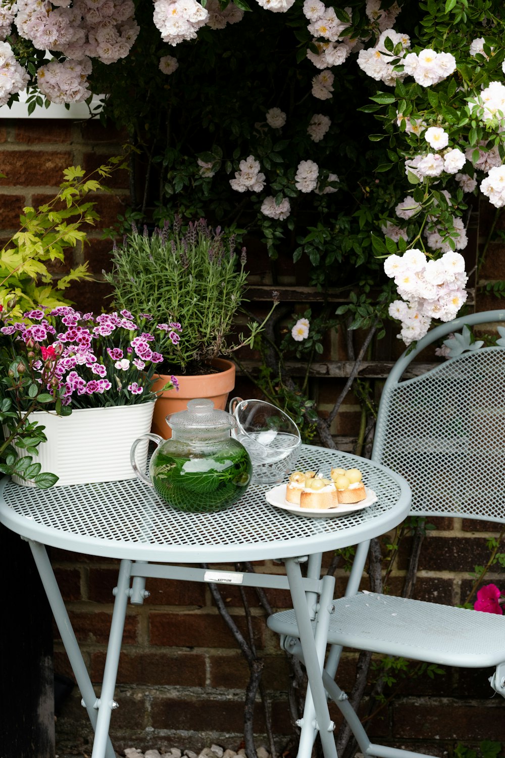 a table and chairs with flowers in the background