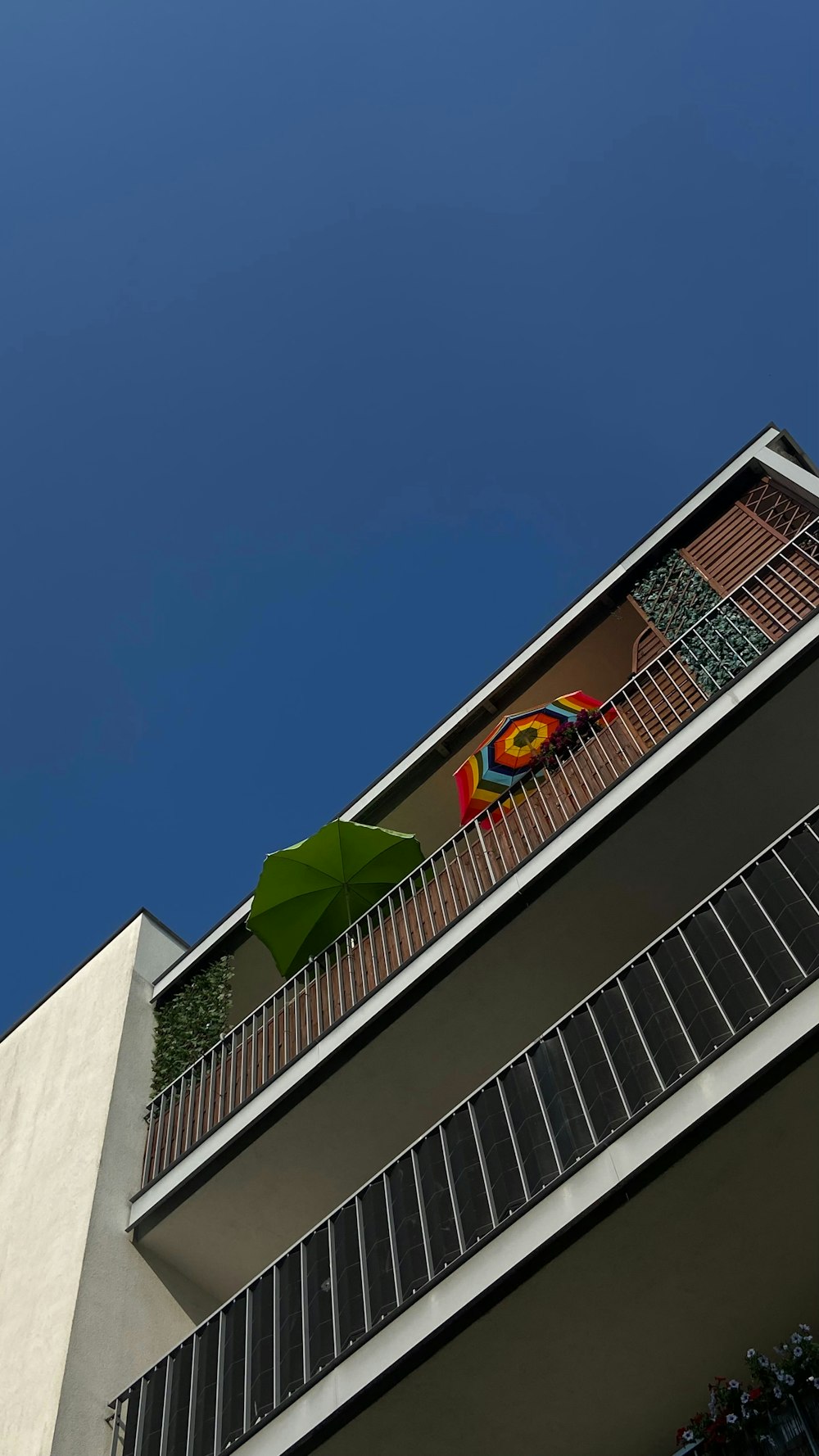 a building with a green umbrella on the balconies