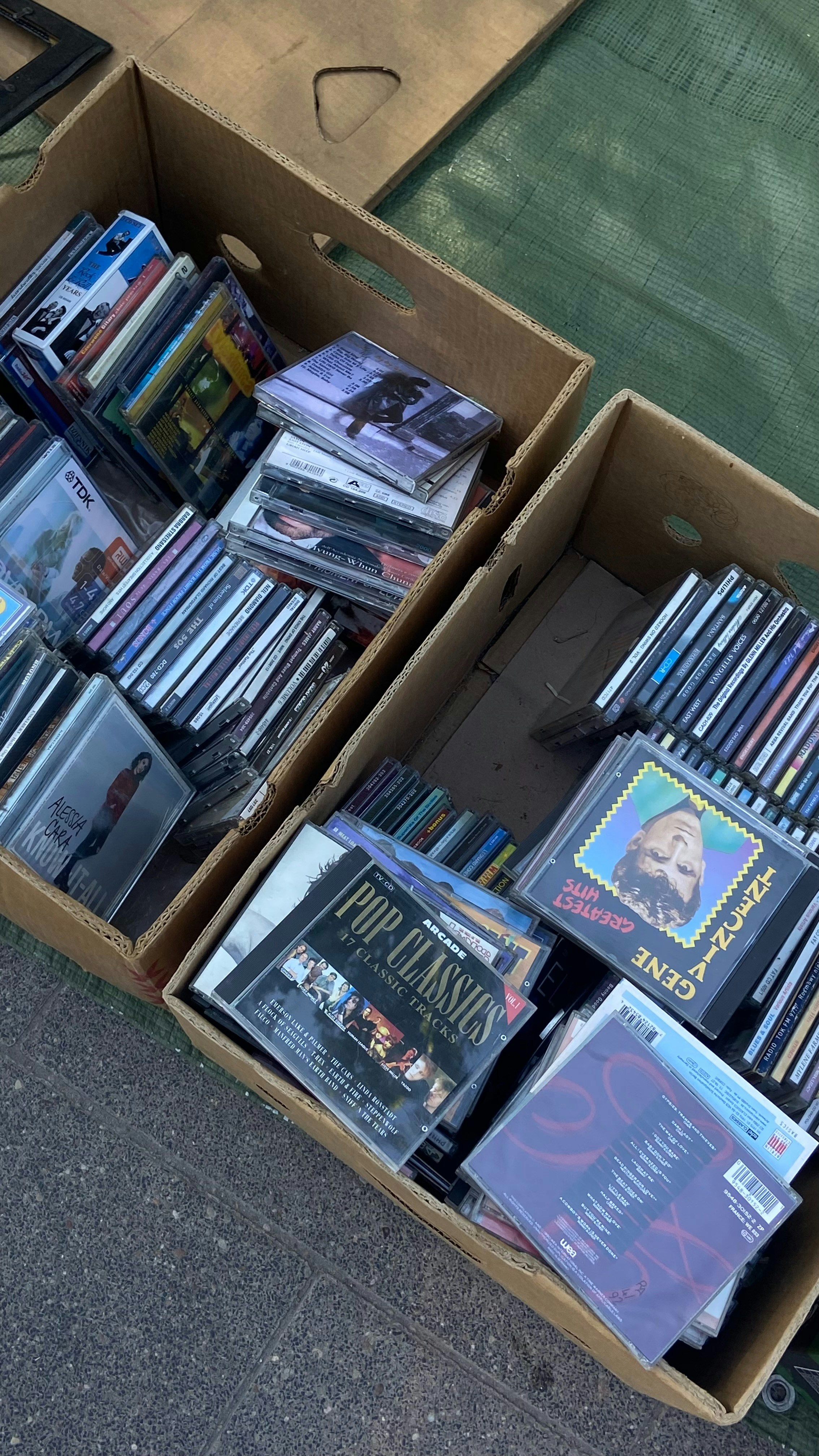 A cardboard box filled with dvd's sitting on a sidewalk photo – Free ...