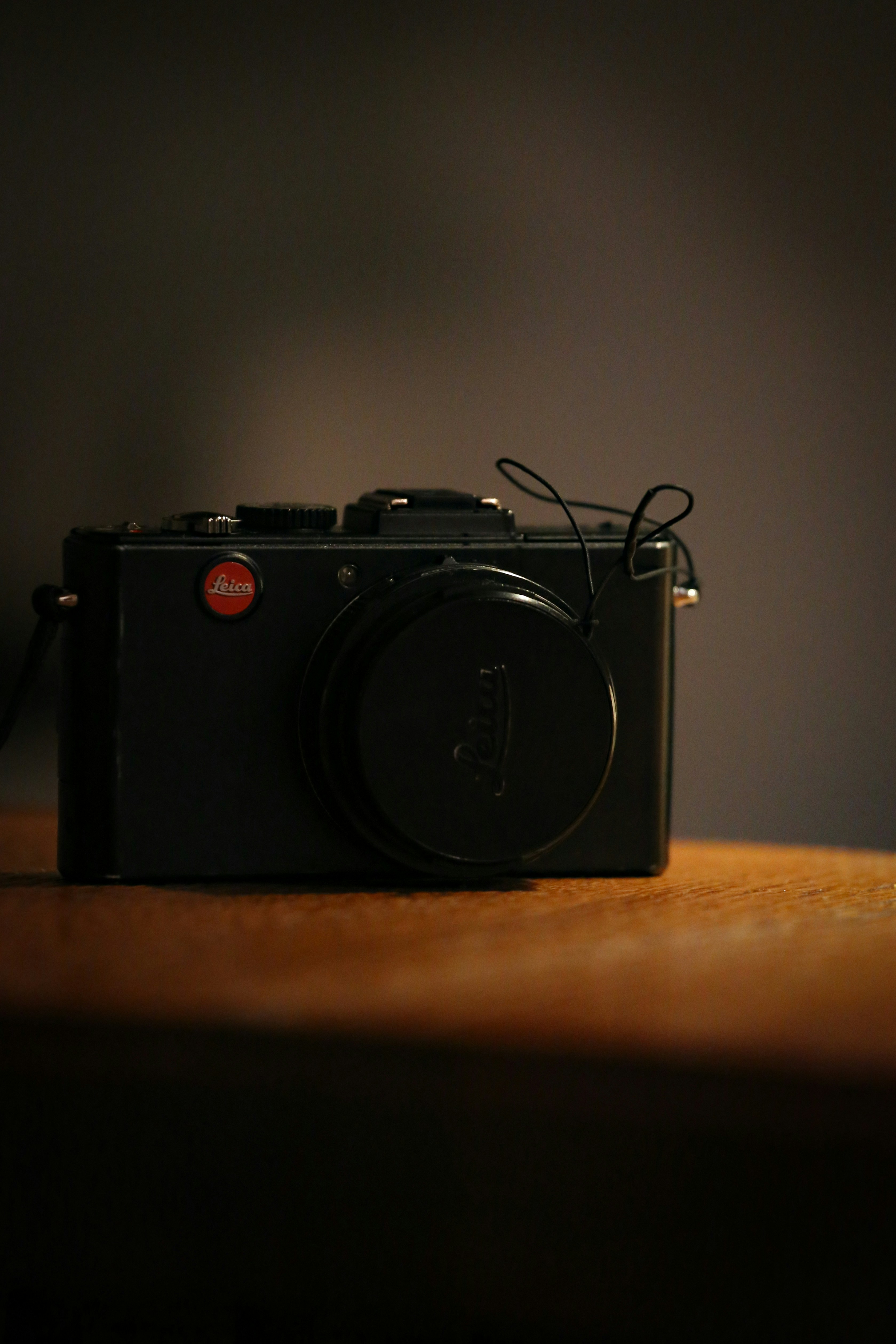 una macchina fotografica nera seduta sopra un tavolo di legno