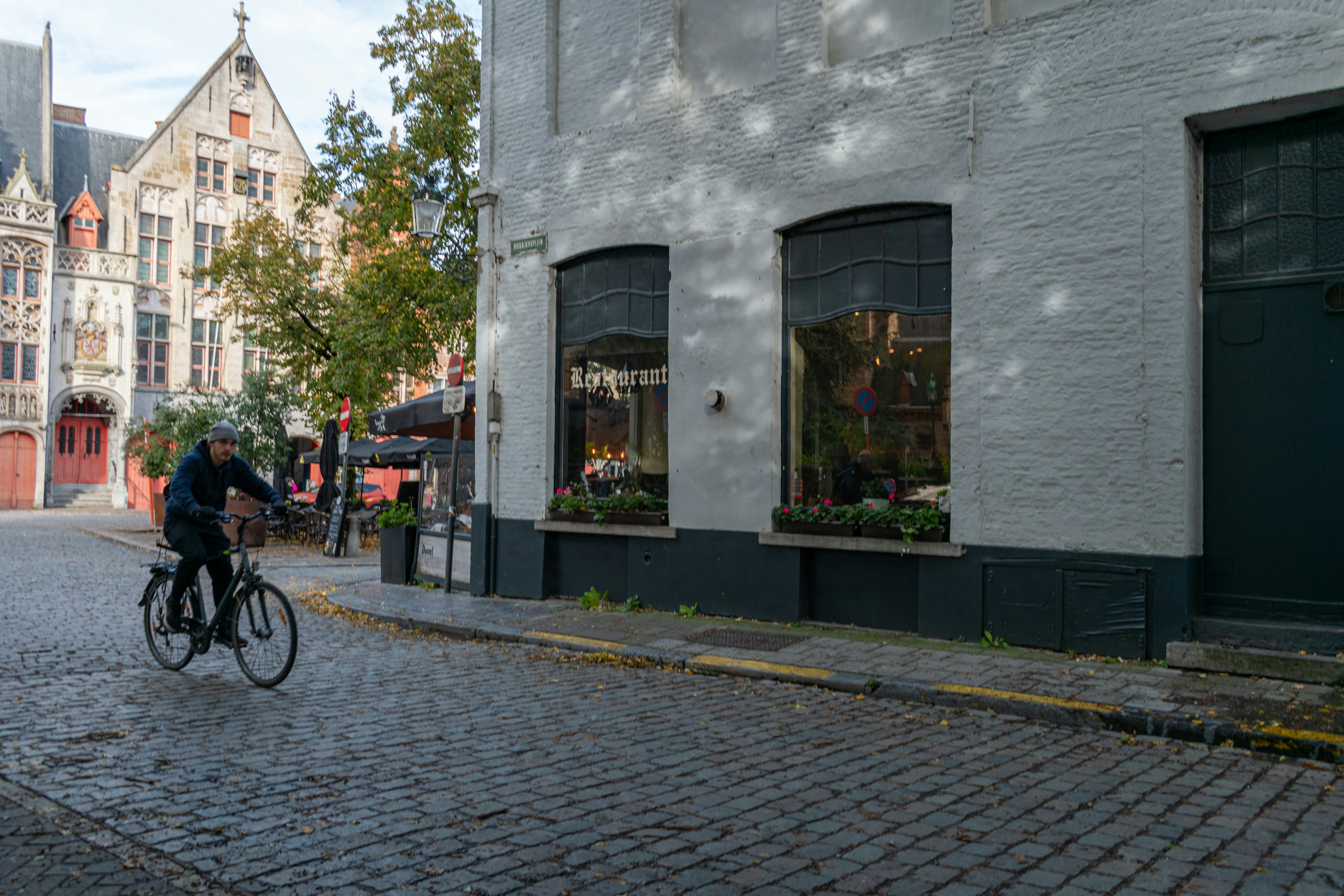 a man riding a bike down a cobblestone street
