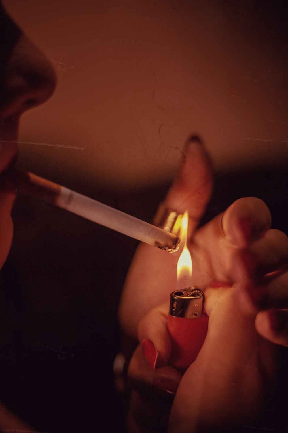 a woman lighting a cigarette with a lighter in her hand