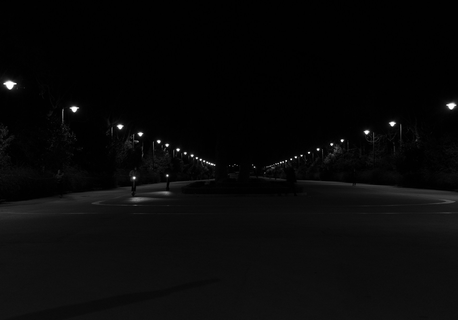 a black and white photo of a street at night