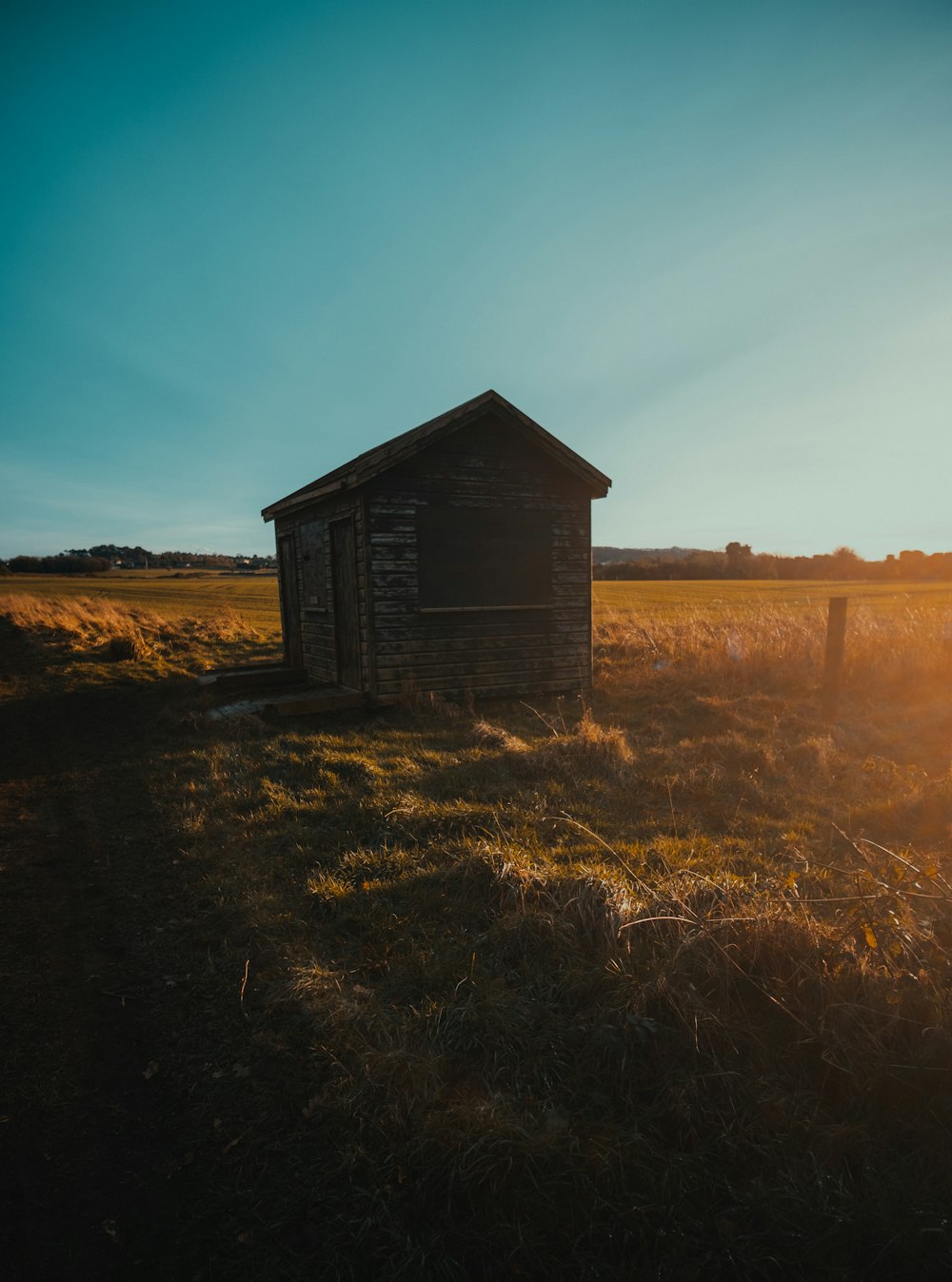 a small building sitting in a field of grass