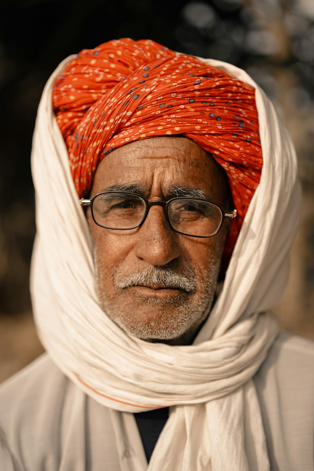 a man wearing a red turban and glasses