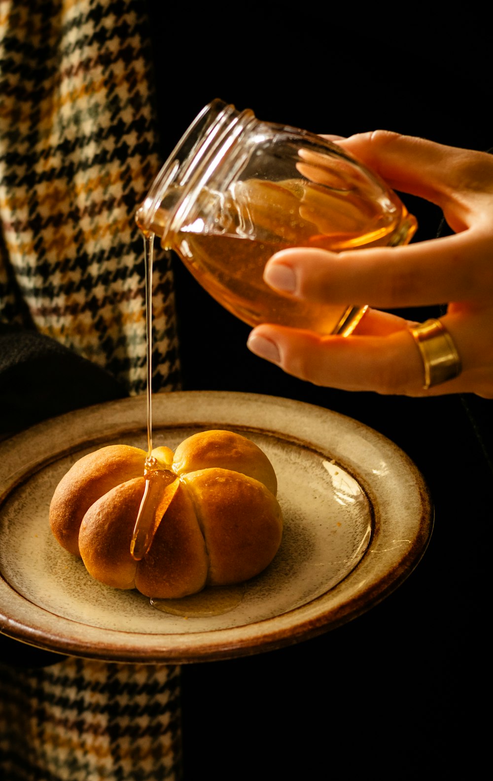 a person pouring syrup onto a plate of food