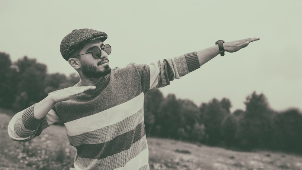 a man in a striped shirt pointing at something