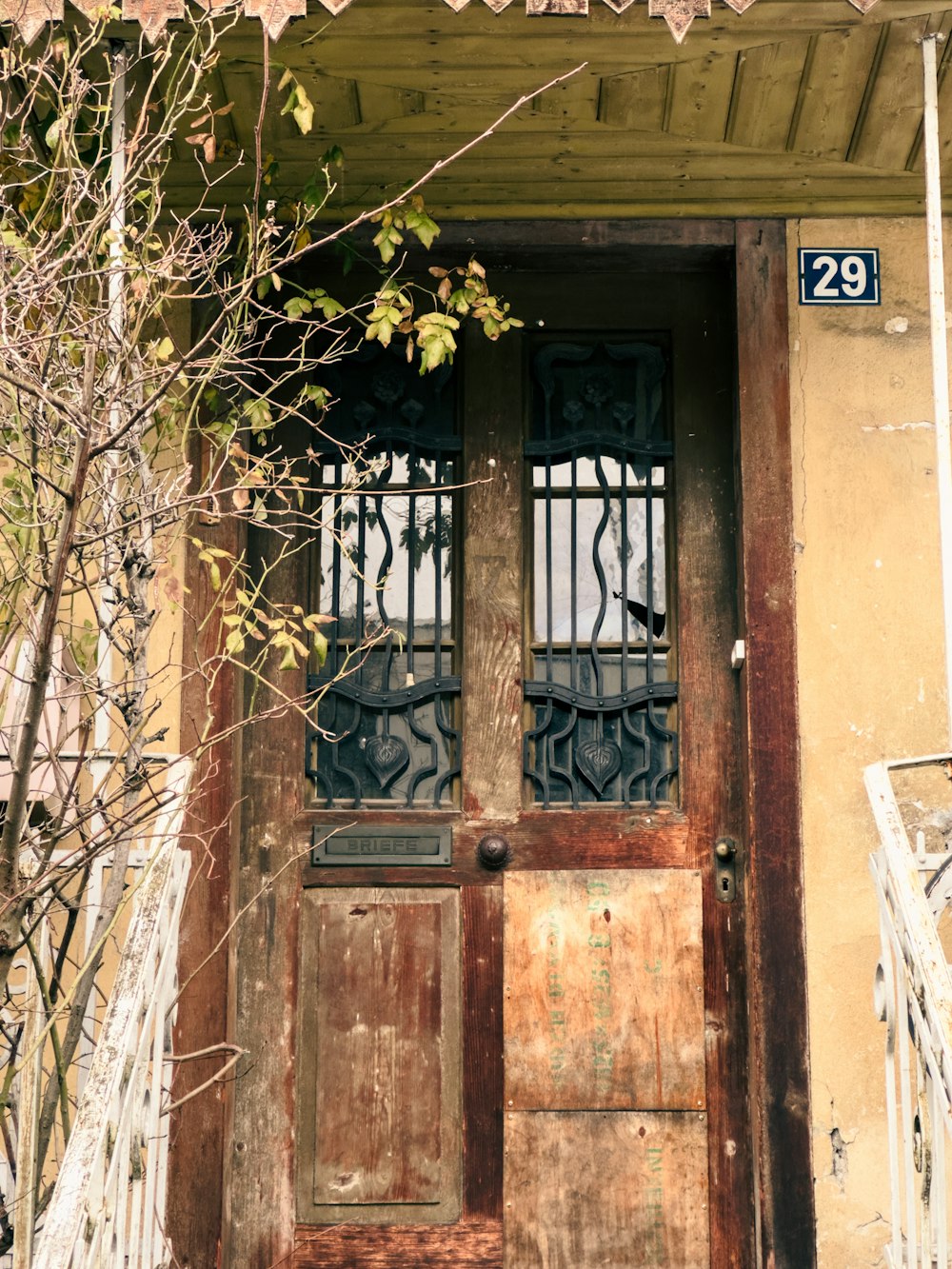 a wooden door with wrought iron bars and a number 29 sign