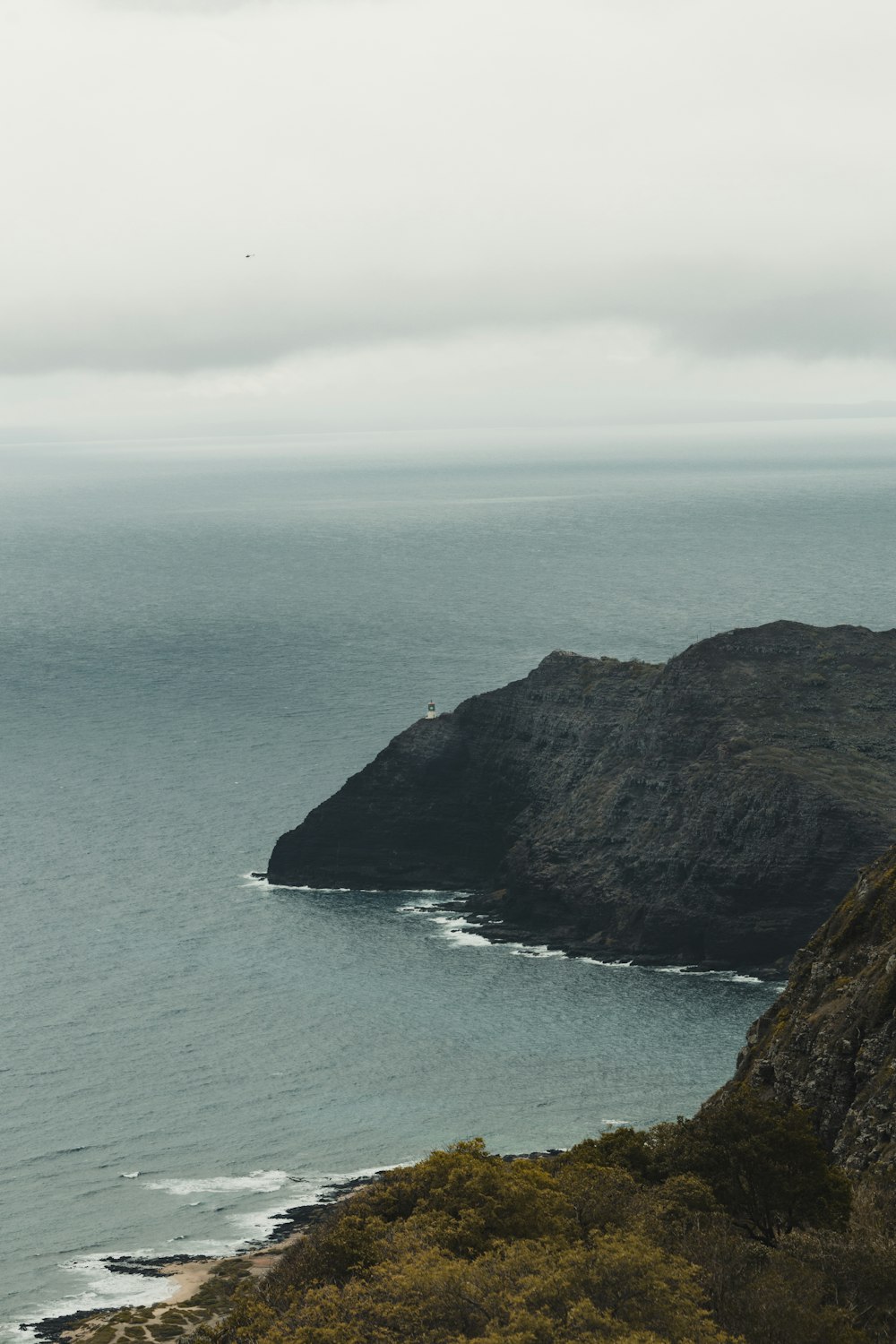 a large body of water sitting next to a lush green hillside