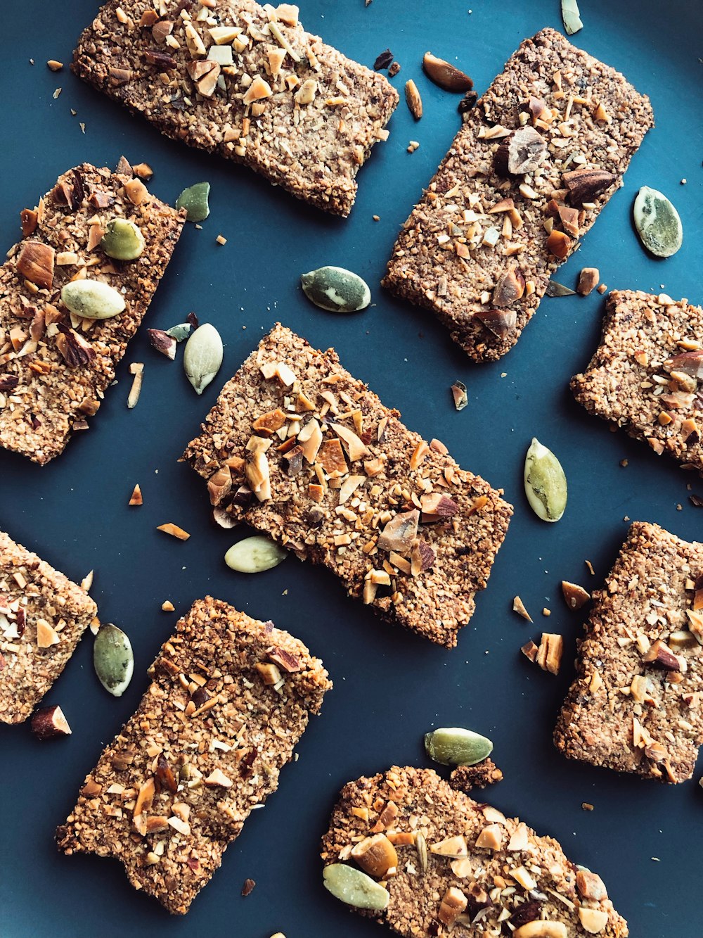 a blue plate topped with granola bars and nuts