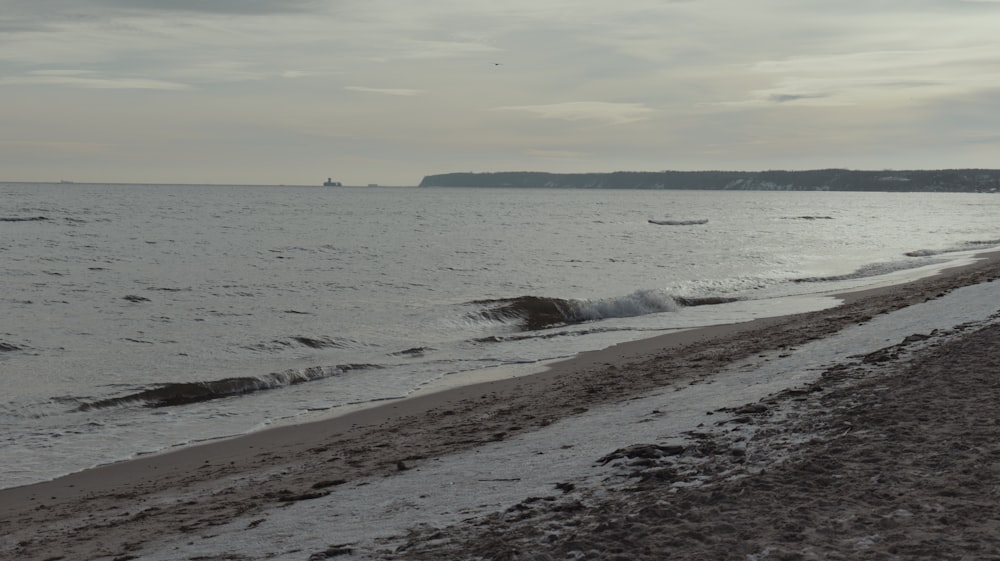 a beach with a boat in the distance