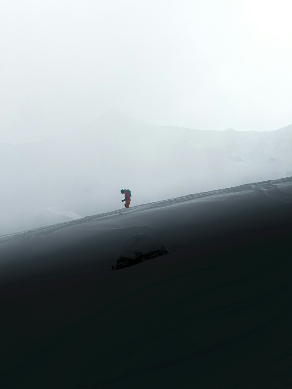 a person walking on a hill in the fog