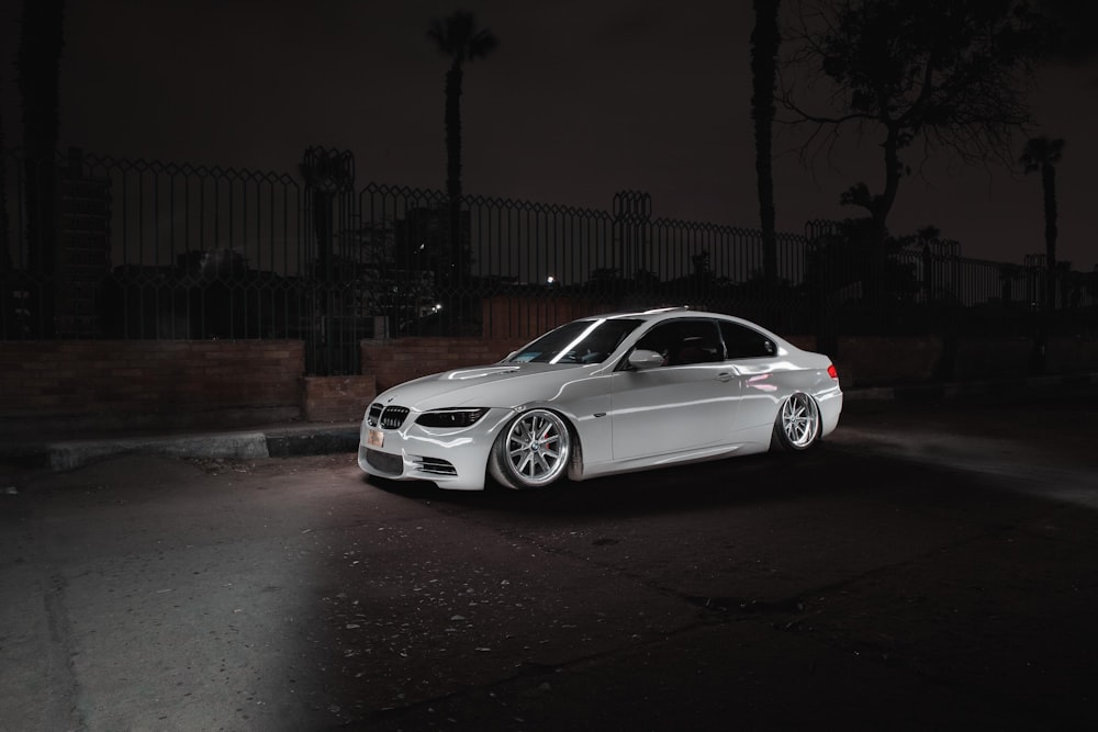 a white car parked in a parking lot at night