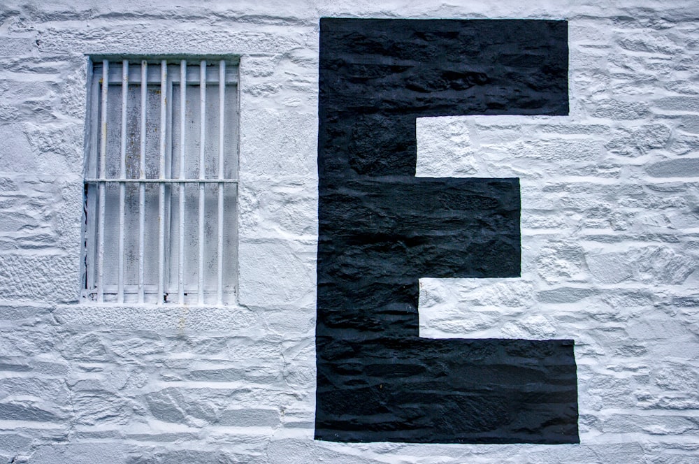 a black and white number five painted on a white wall