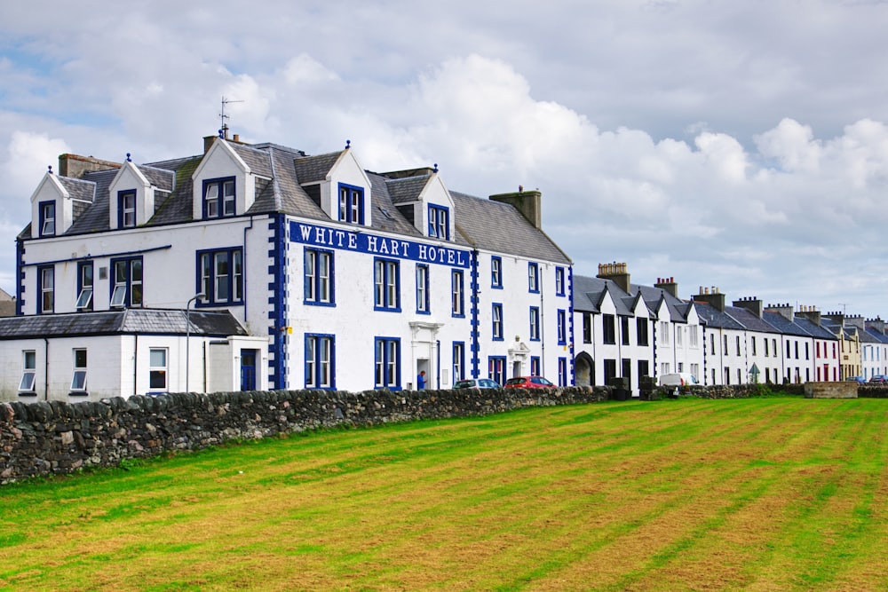 a row of white houses on a grassy field