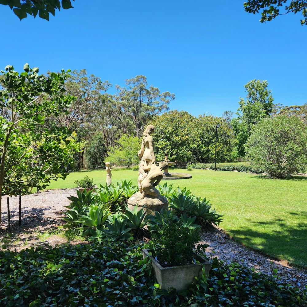 a garden with a statue in the middle of it