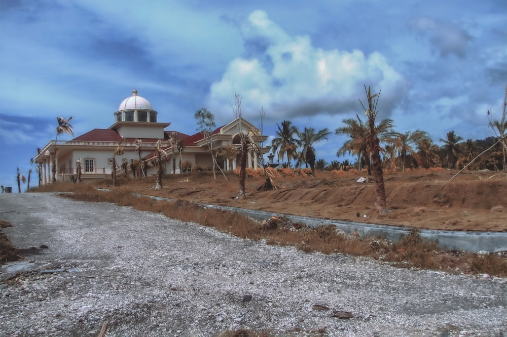 a large building sitting on top of a dirt road