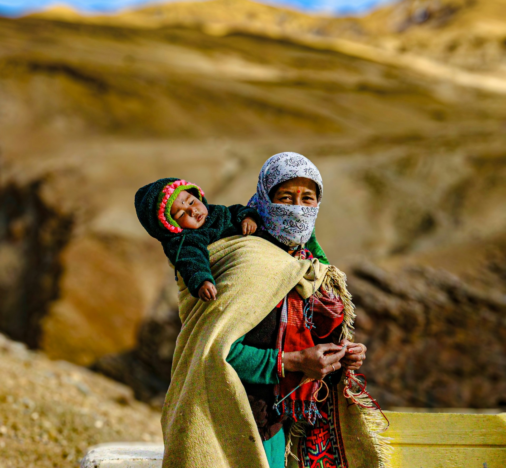 a woman carrying a child on her back