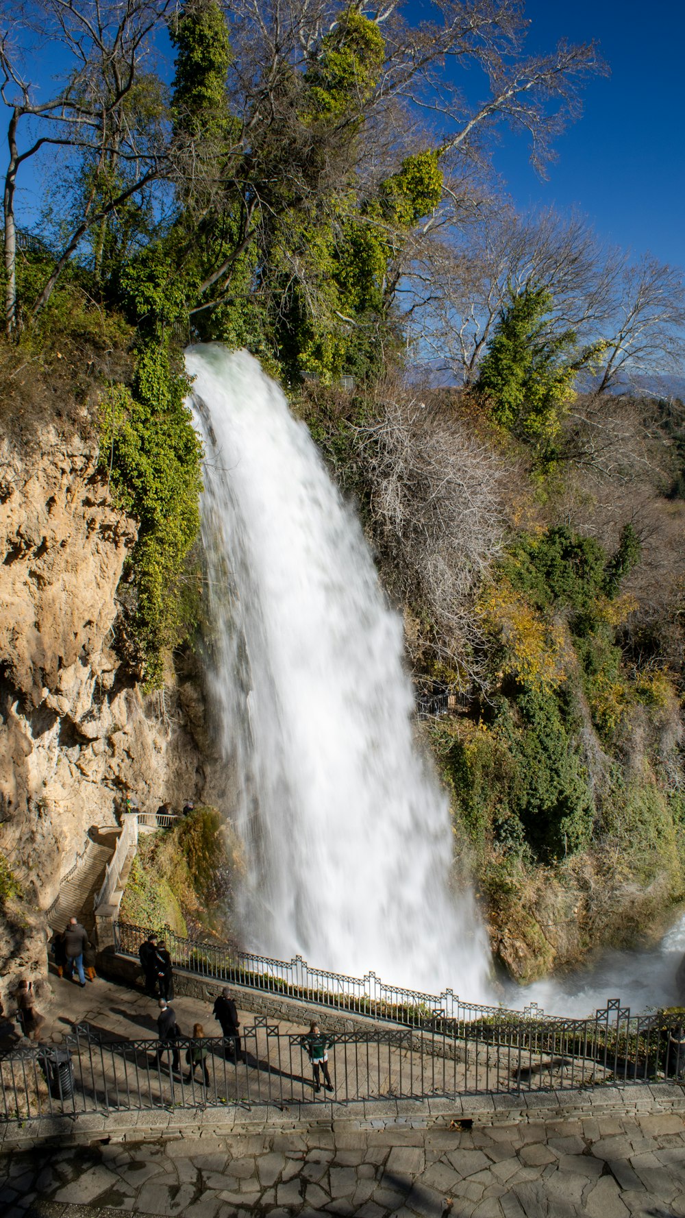 a group of people standing in front of a waterfall