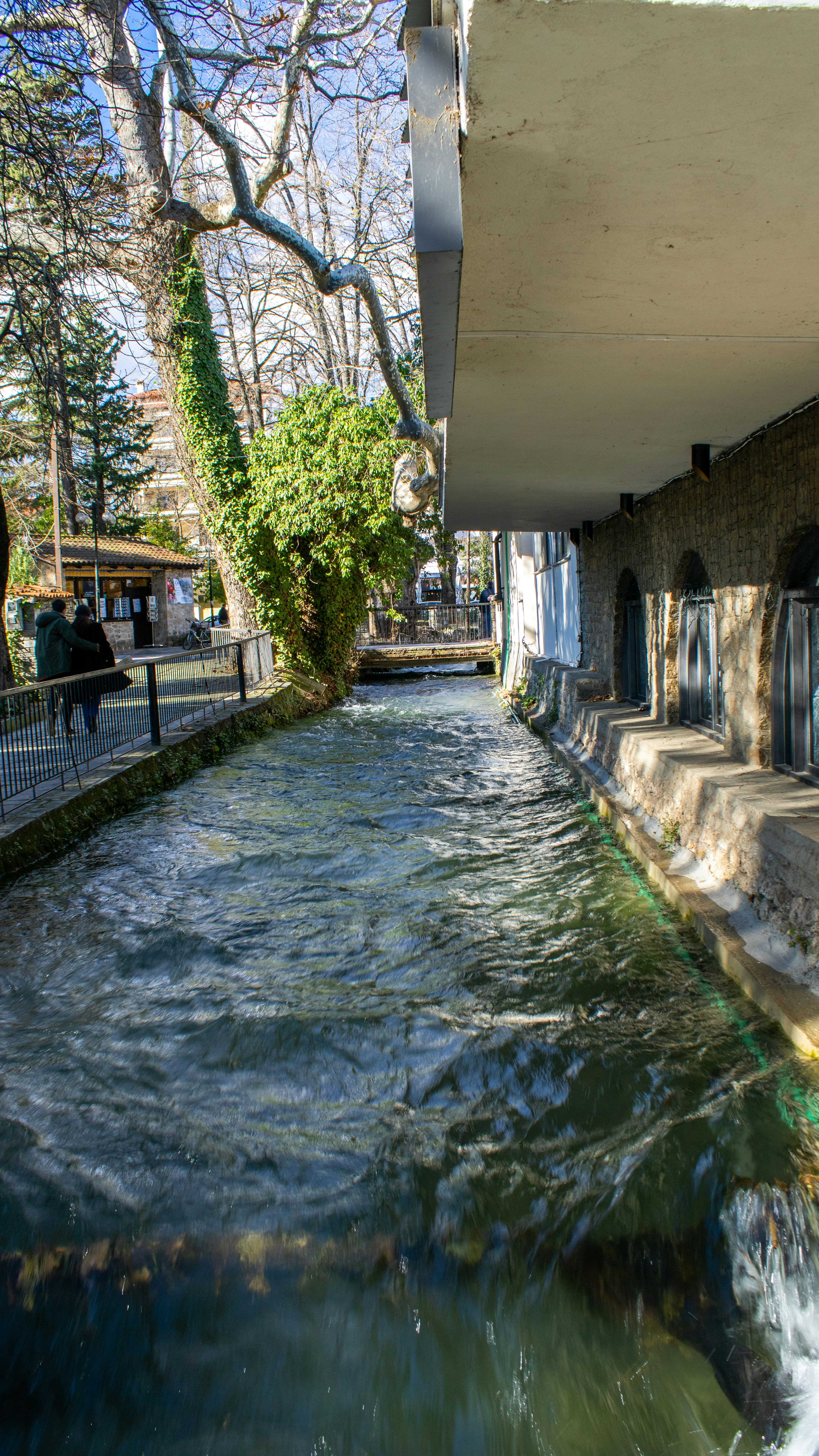 a river running under a bridge next to a building