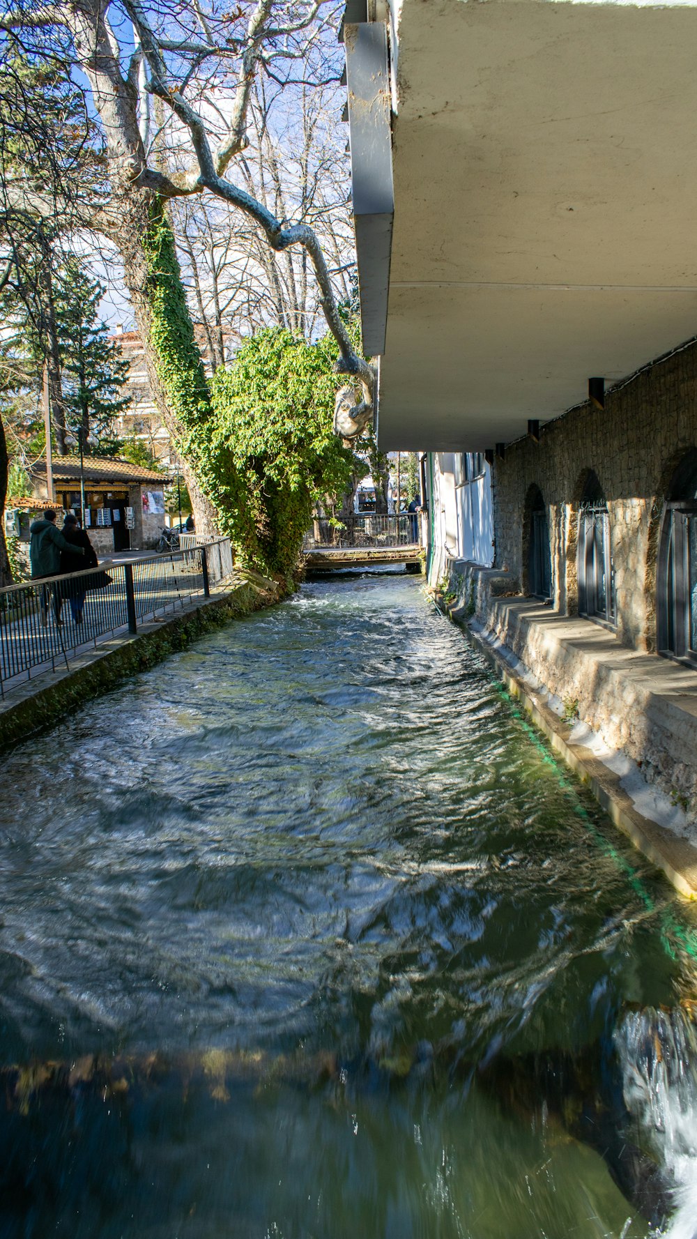 a river running under a bridge next to a building