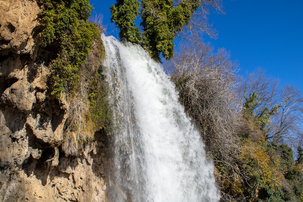 a tall waterfall with water cascading down it's side