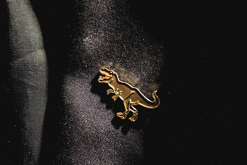 a gold brooch with a lizard on it