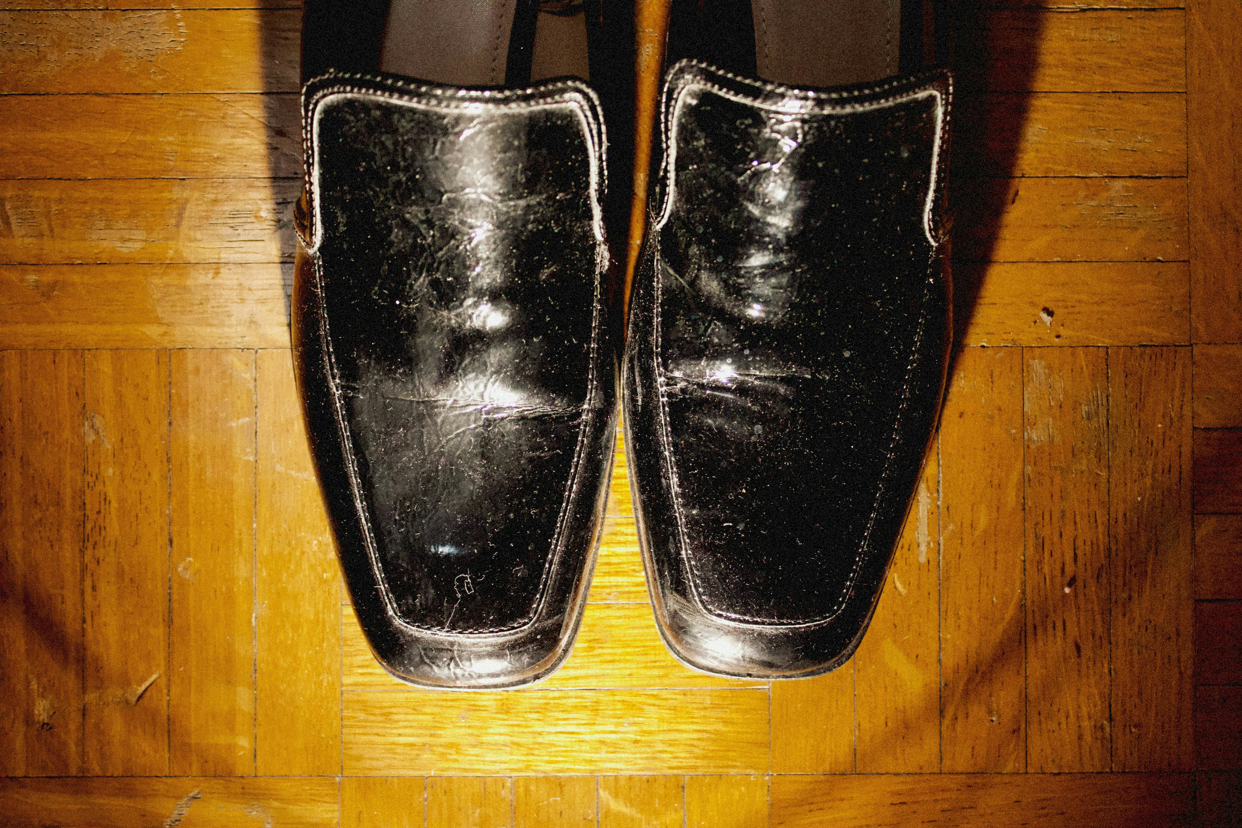 a pair of black shoes sitting on top of a wooden floor