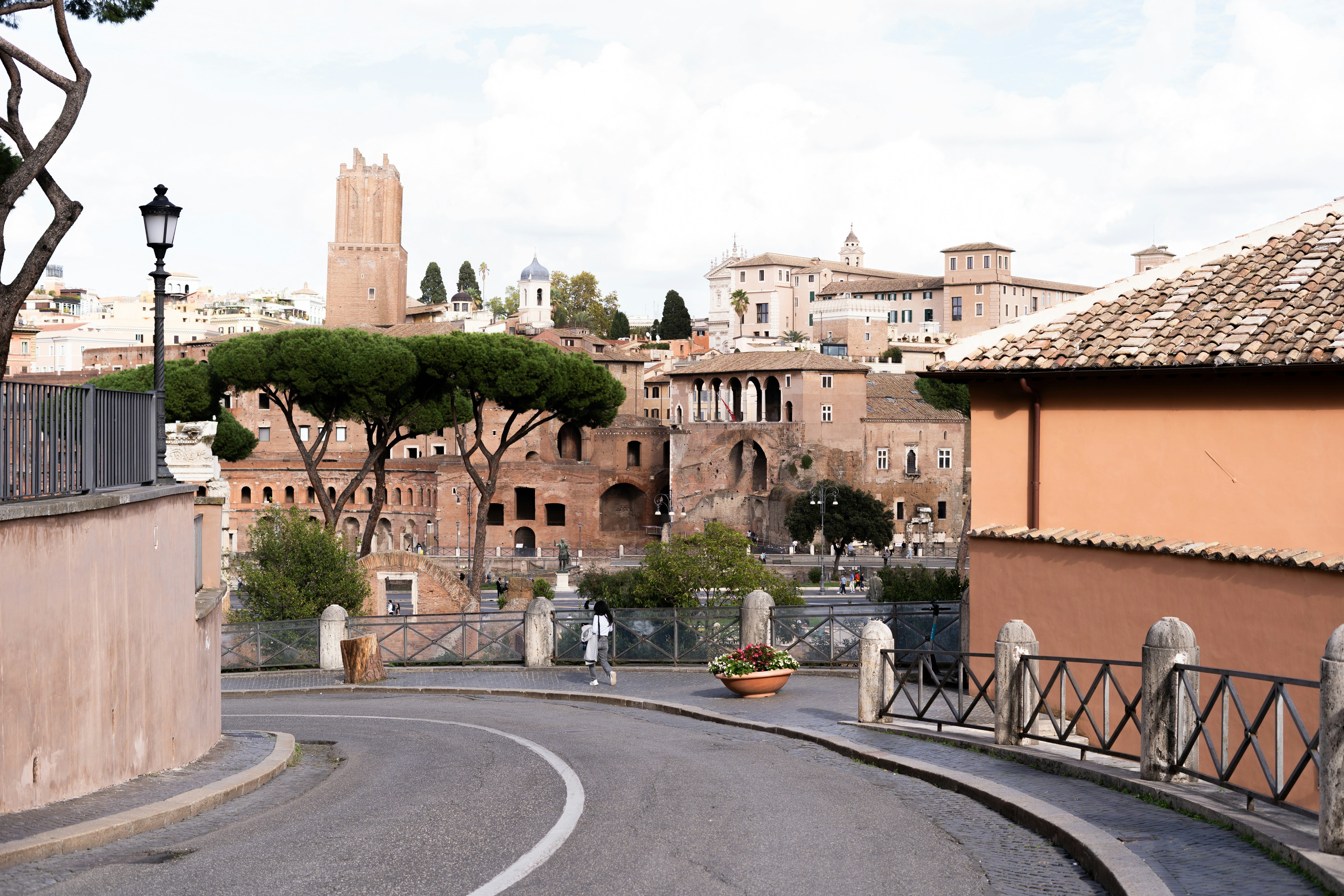 a winding road in a small town with a clock tower in the background