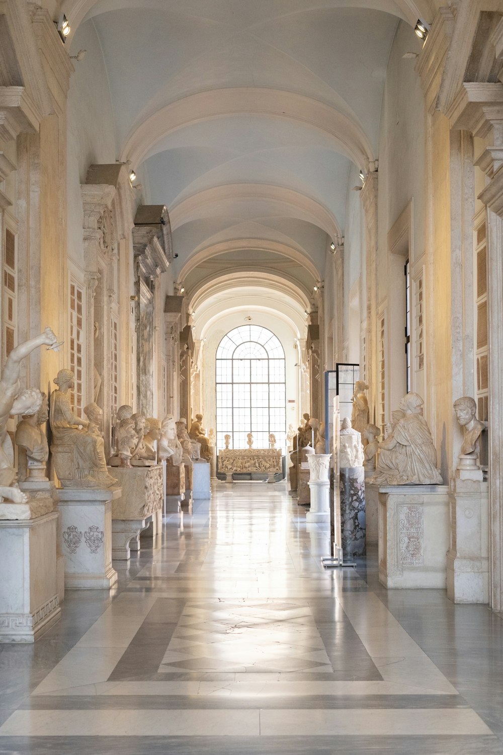 a long hallway with statues on either side of it