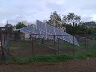 a fence with a bunch of solar panels on top of it