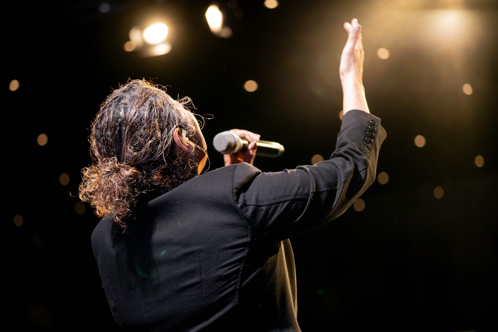 a woman standing on a stage holding a microphone