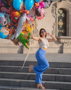 a woman is posing with a bunch of balloons