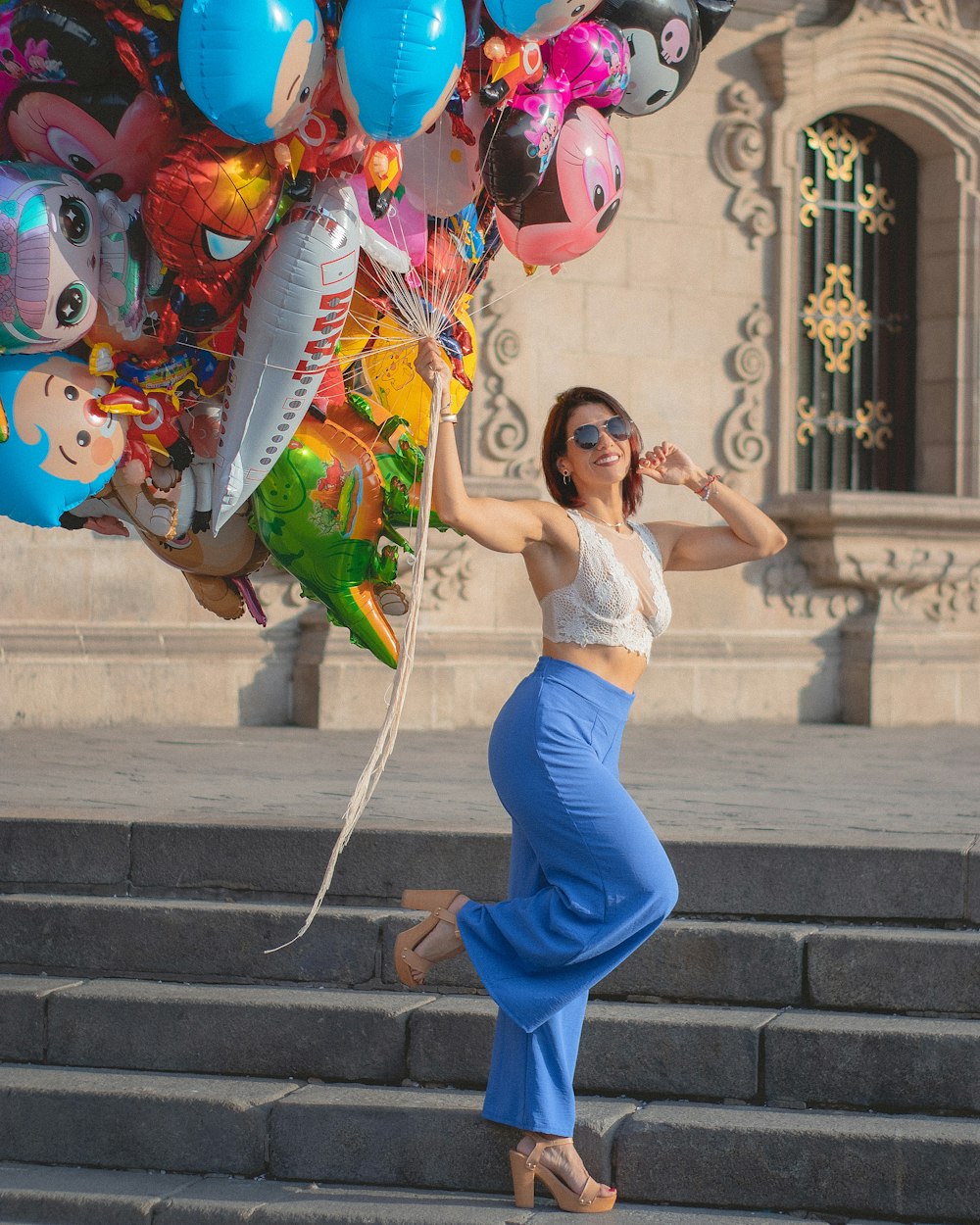 a woman is posing with a bunch of balloons