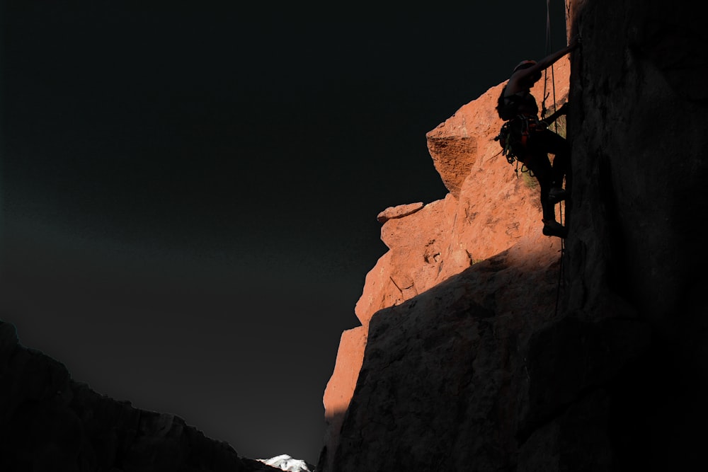 a man climbing up the side of a mountain