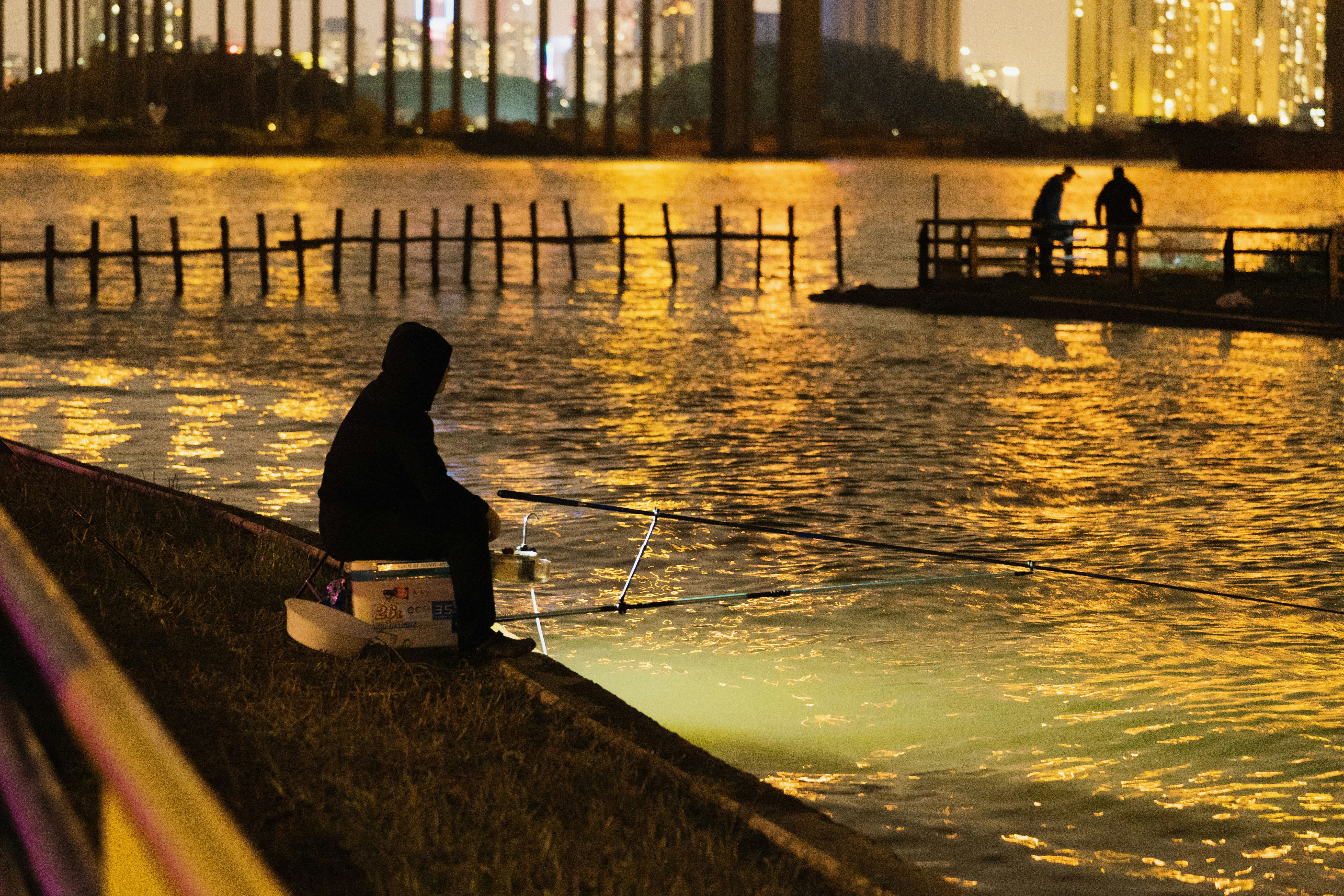 a man sitting on a wall next to a body of water
