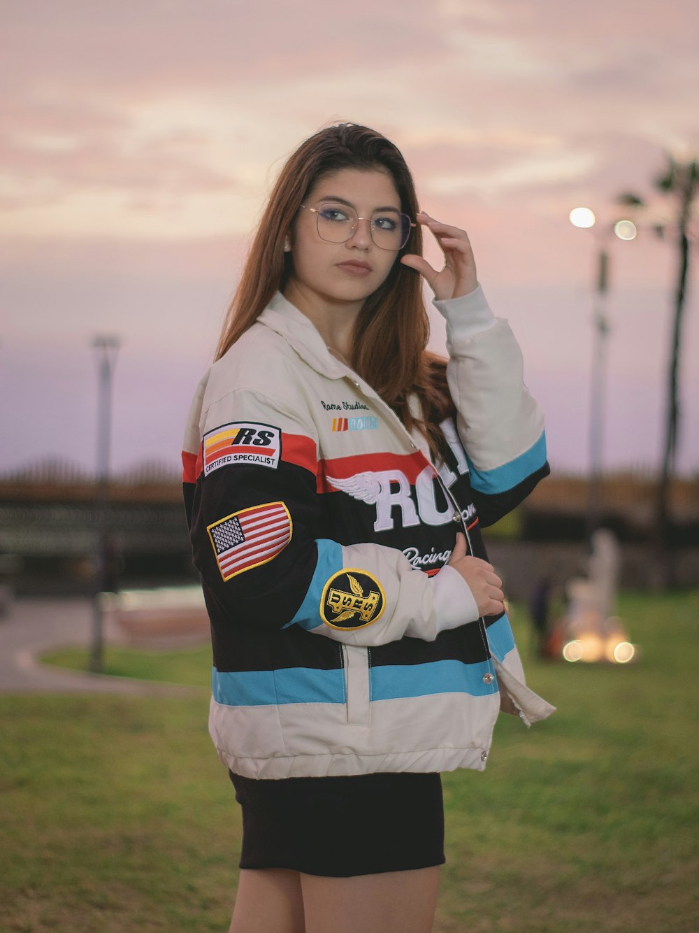 a woman wearing a jacket and glasses posing for a picture