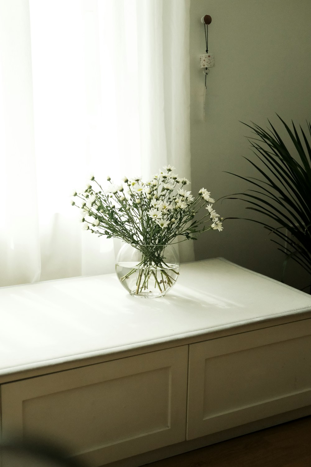 a vase of flowers sitting on top of a white counter