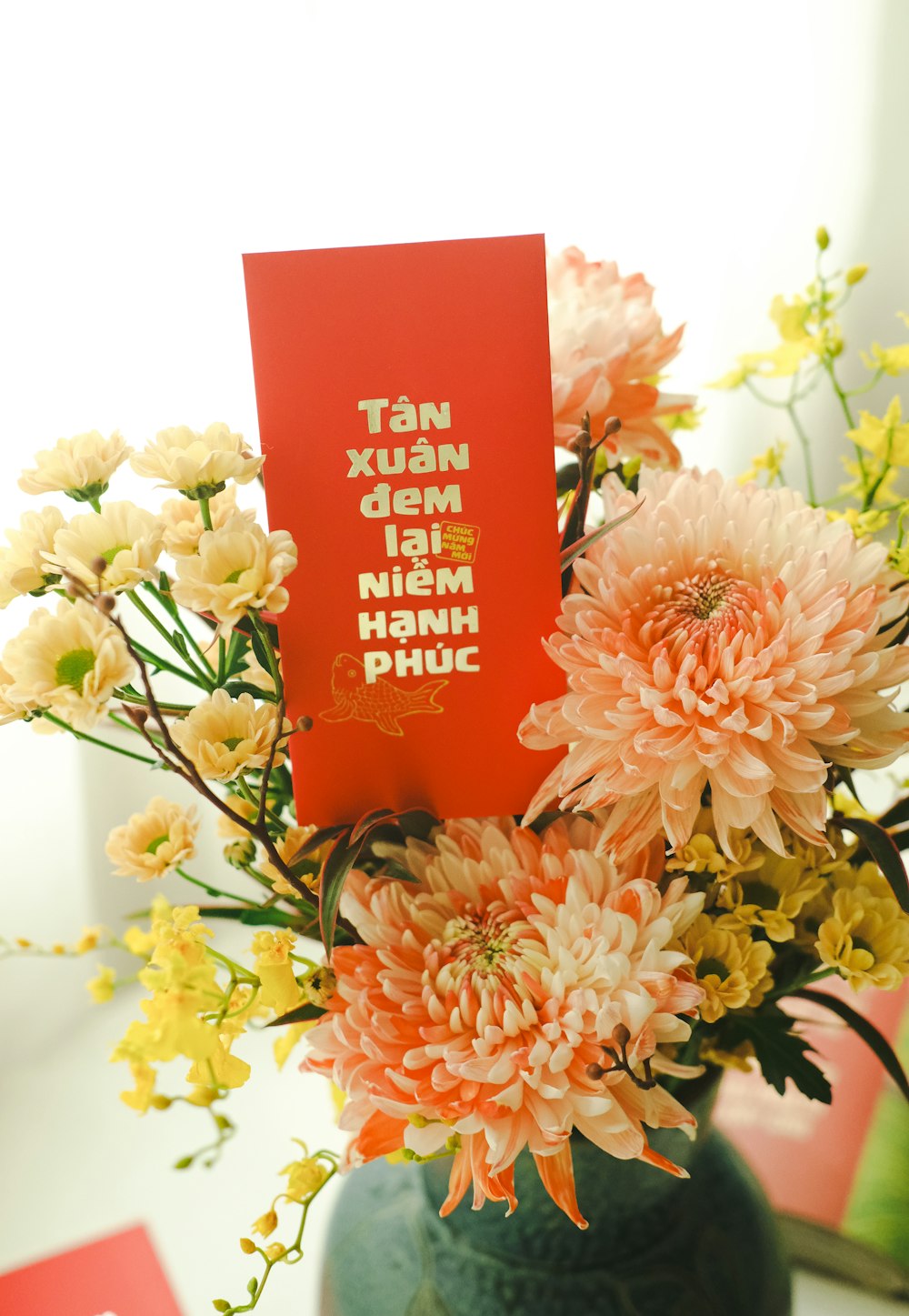 a vase filled with flowers and a red card