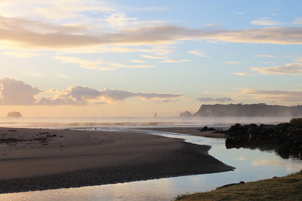 a body of water sitting on top of a sandy beach