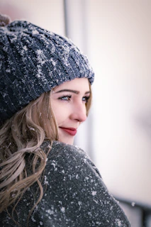 a woman wearing a gray sweater and a gray hat