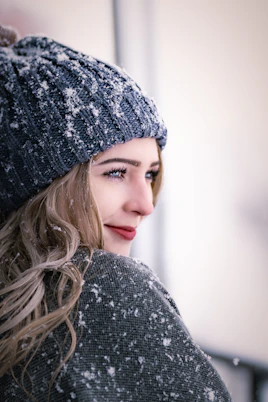a woman wearing a gray sweater and a gray hat