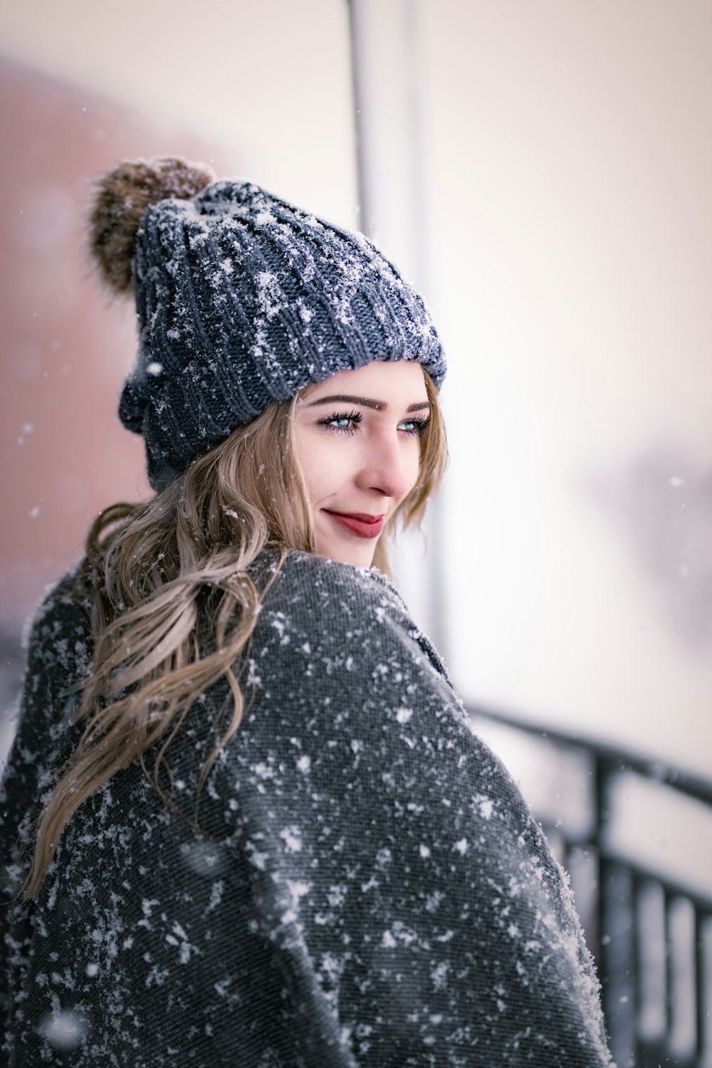 a woman wearing a hat and coat in the snow