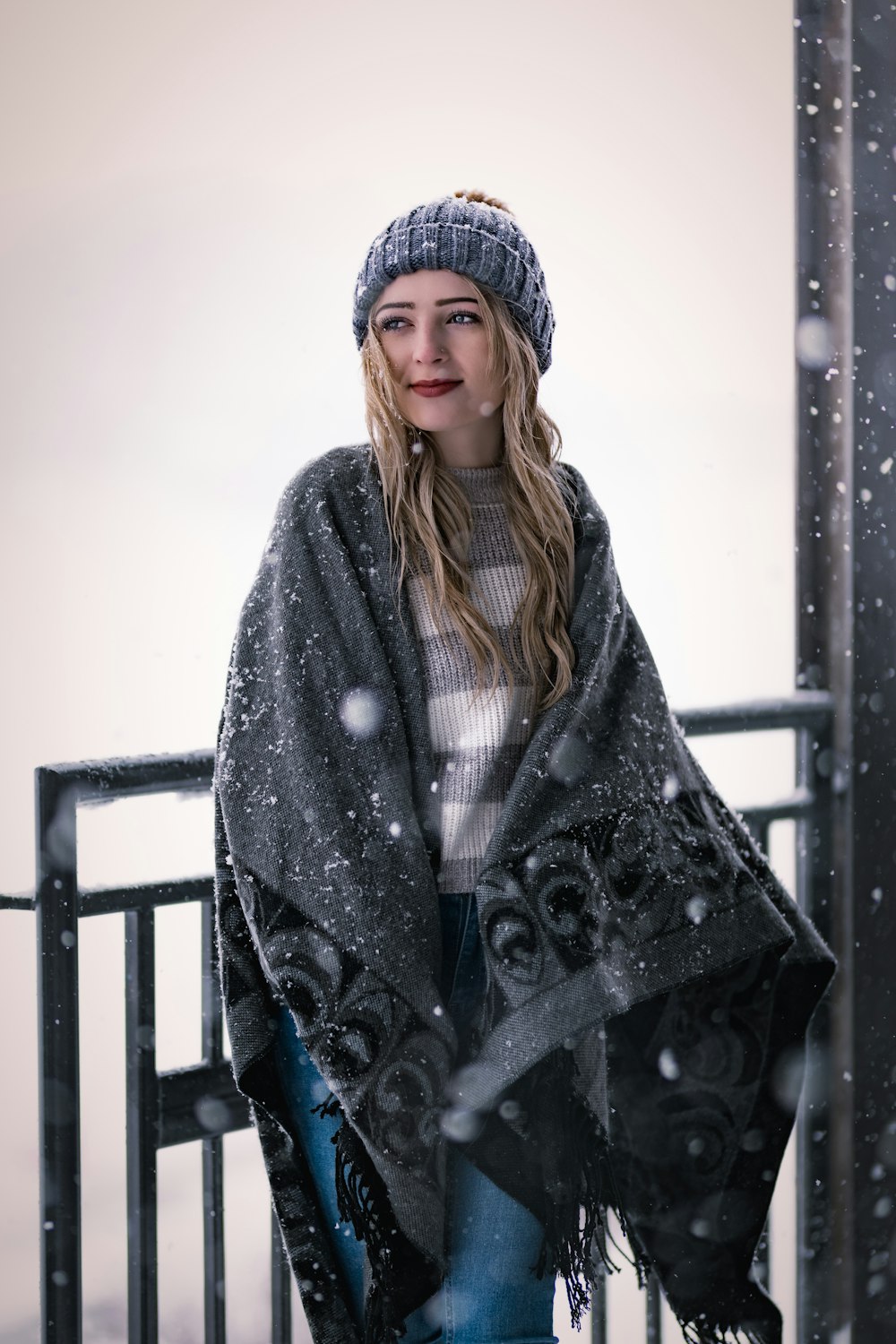 a woman standing on a balcony in the snow