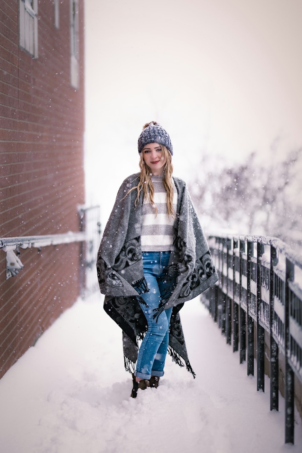 a woman standing in the snow wearing a coat